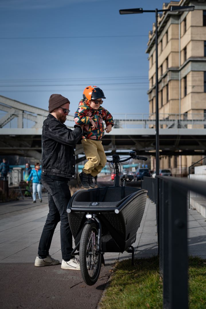 father putting his son to cargobike